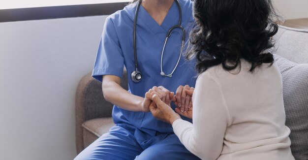 Homecare nursing service and elderly people cardiology healthcare Close up of young hispanic female doctor nurse check mature caucasian man patient heartbeat using stethoscope during visit