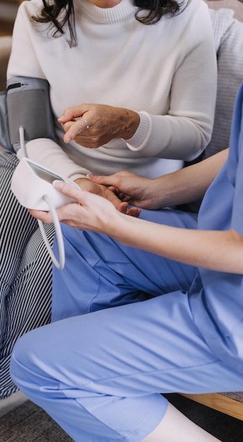 Homecare nursing service and elderly people cardiology healthcare Close up of young hispanic female doctor nurse check mature caucasian man patient heartbeat using stethoscope during visit