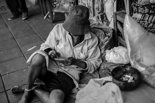 Foto mendicante senzatetto scrive qualcosa nel suo taccuino., foto in bianco e nero.