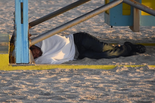 Photo homeless man sleeping on a beach in miami