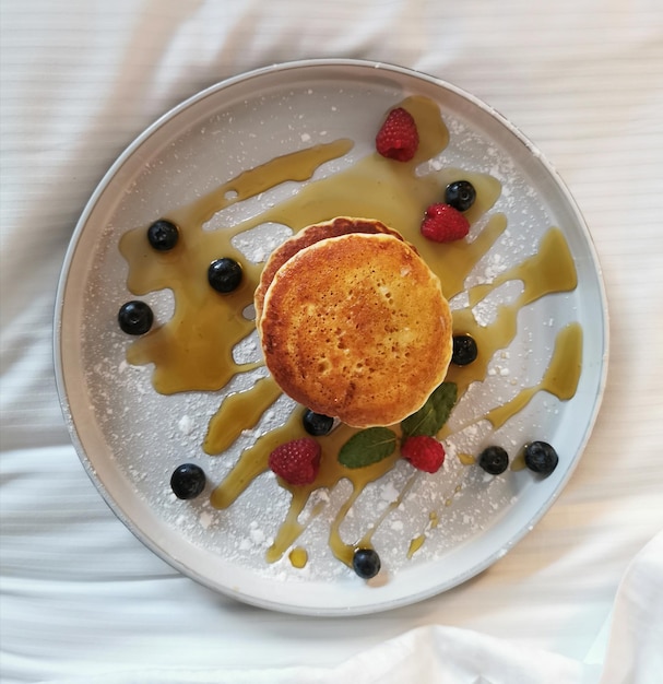 Frittelle d'aria americane fatte in casa con mirtilli, lamponi e miele. concetto di cottura e cibo