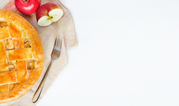 Homemade american apple pie with apples on white table with copy space