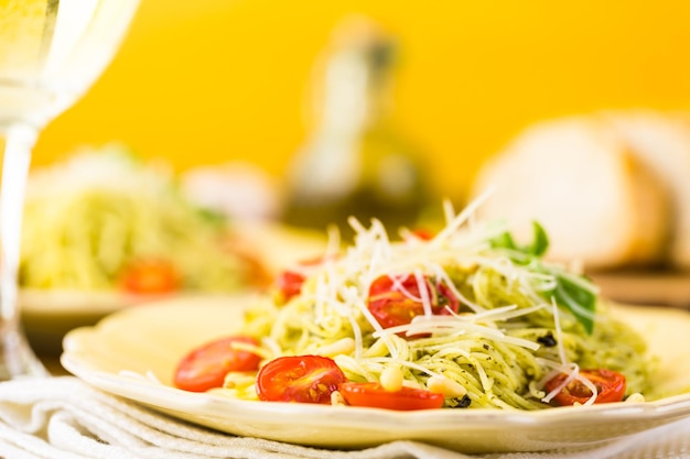 Homemade angel hair pasta with pesto sauce and roasted cherry tomatoes