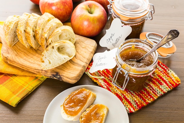 Домашнее яблочное масло и свежеиспеченный хлеб на столе.