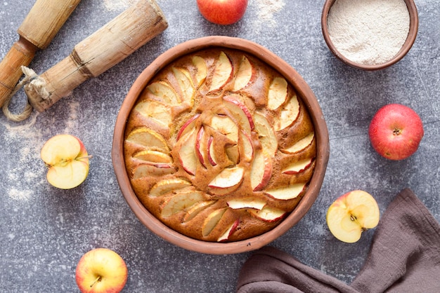 Домашний яблочный пирог в керамической тарелке на сером фоне