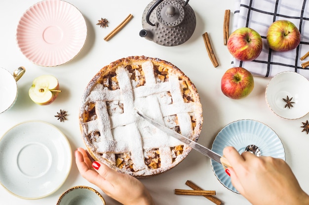 Homemade apple pie sprinkled with powdered sugar on a family table 