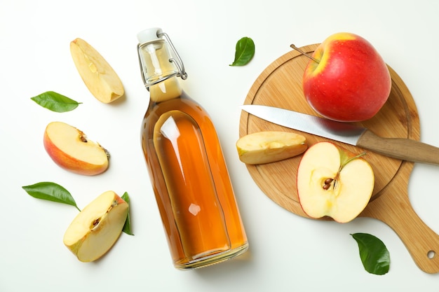 Homemade apple vinegar and ingredients on white