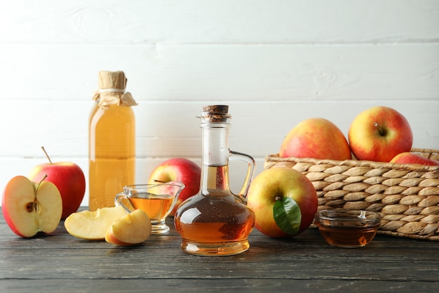 Домашний яблочный уксус и ингредиенты на деревянном столе