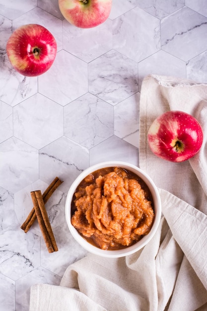 Salsa di mele fatta in casa in una ciotola e frutta fresca sul tavolo alimenti biologici vista dall'alto e verticale