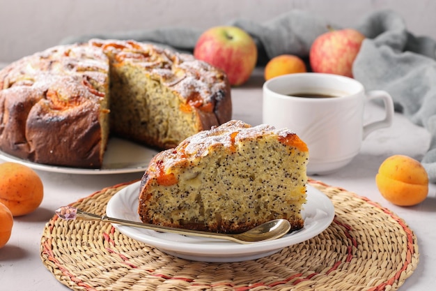 Homemade apricots pie with poppy seeds and apples with cup of coffee on light gray background