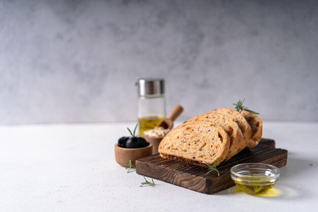 Домашний ремесленный хлеб чиабатта на закваске с оливками и розмарином на  белом абстрактном столе | Премиум Фото