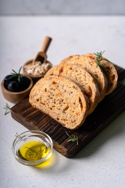 Домашний ремесленный хлеб чиабатта на закваске с оливками и розмарином на белом абстрактном столе