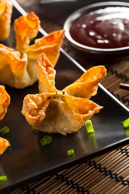 Photo homemade asian crab rangoons with sweet and sour sauce