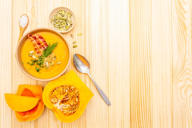 Homemade autumn hot pumpkin cream soup with smoked bacon and seeds