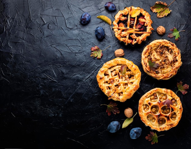 Torte autunnali fatte in casa con pere, mele, uva e prugne. torta di frutta di stagione. spazio per il testo