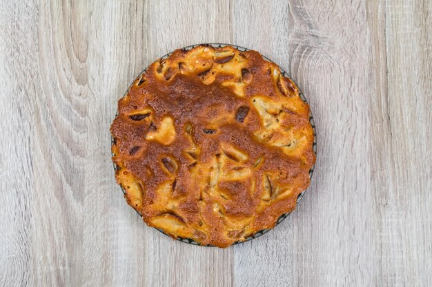 Homemade baked apple pie in a plate on a wooden table ready to eat