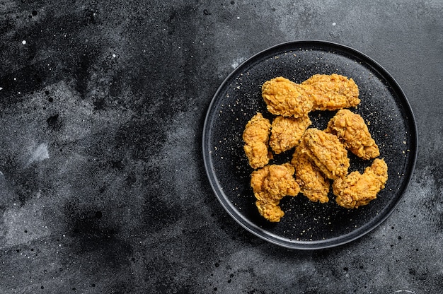 Homemade baked crispy chicken wings.  Black background