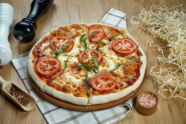 Pizza margherita al forno fatta in casa con pomodori e mozzarella, tavolo in legno salsa rossa vista da vicino, piatto laici. cucina italiana tradizionale