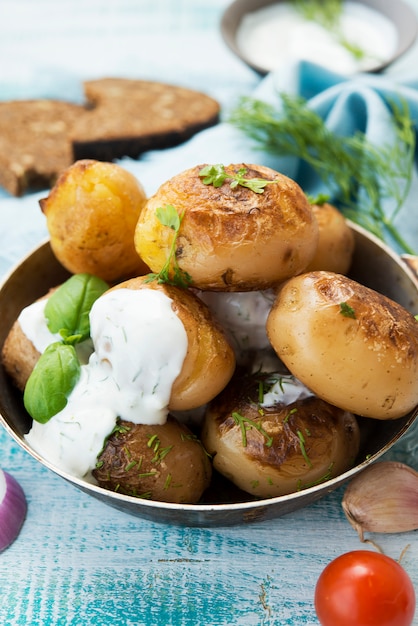 Homemade baked potatoes with herbs and sour cream