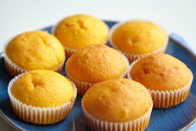 Homemade bakery muffins on blue plate on dinner table