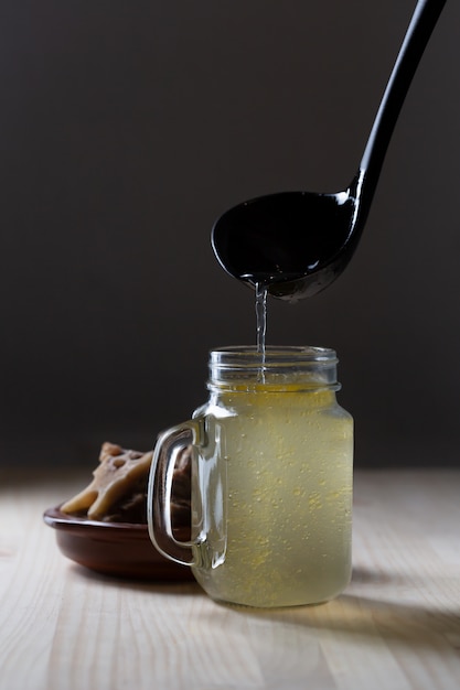 Homemade Beef Bone Broth in Glass Storage Jar on a black space