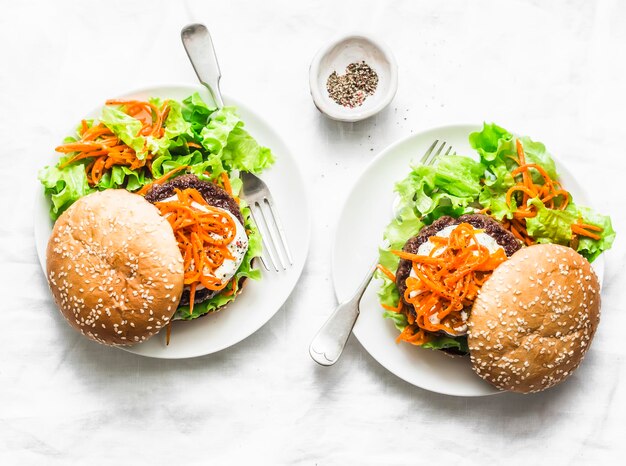 Homemade beef burger with spicy marinated carrots and green salad delicious snack brunch tapas on a light background