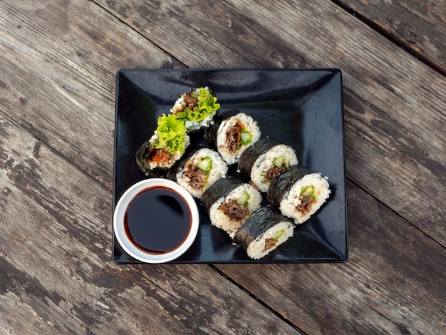 Homemade beef shusi on a black plate old wooden table