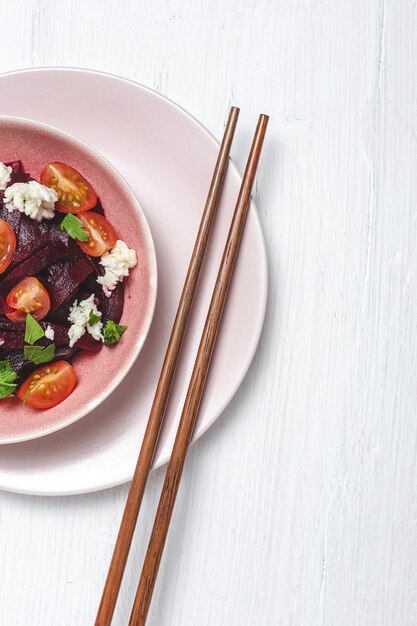 Homemade Beet Salad in bowl with Walnuts, Mozzarella, Parsley, and Cherry Tomatoes. Vegan food concept