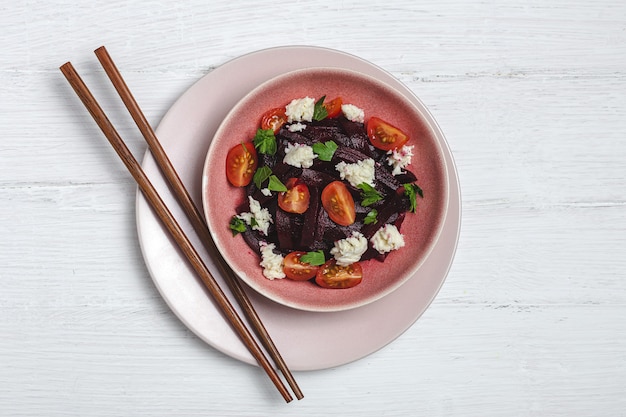 Homemade Beet Salad in bowl with Walnuts, Mozzarella, Parsley, and Cherry Tomatoes. Vegan food concept