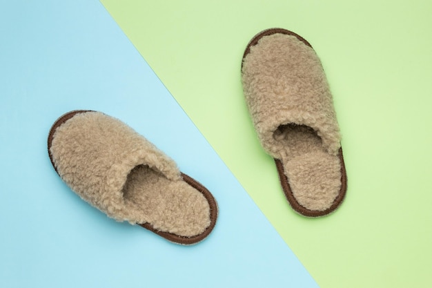 Homemade beige slippers on a twotone background Comfortable shoes for home