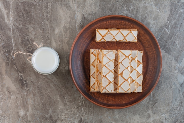 Homemade biscuit with cup of milk on grey.