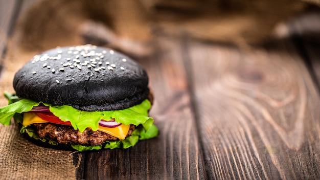 Photo homemade black burger with cheese. cheeseburger with black bun