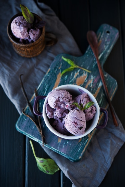 Homemade blueberry ice cream in a Cup on a wooden board