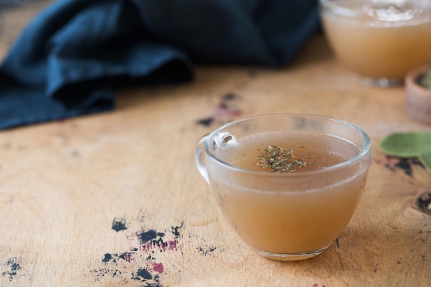 Homemade bone broth in a mug on a wooden table The concept of healthy food