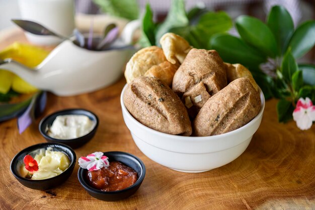 Homemade Brazilian wholegrain breads in a white bowl on a blurred wooden background