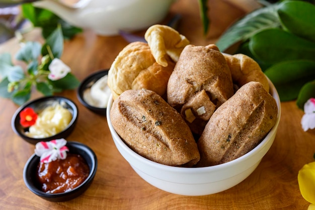 Homemade Brazilian wholegrain breads in a white bowl on a blurred wooden background