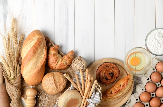 Photo homemade bread or bakery with fresh egg, flour and bakery equipment on white wood