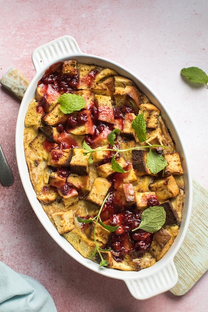 Homemade bread pudding with jam on a pink concrete background Selective focus copy space