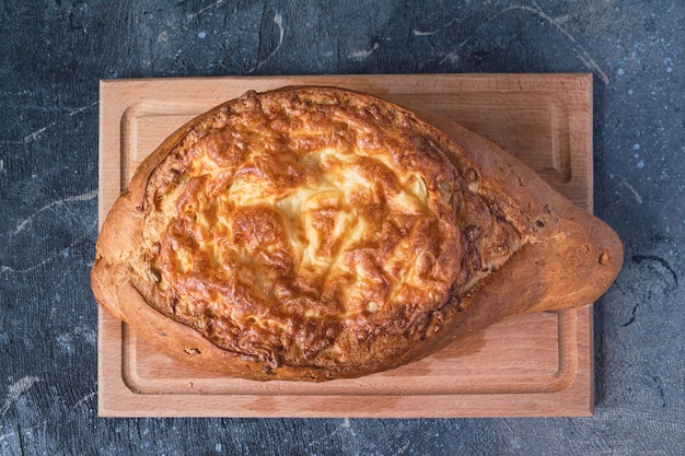 Homemade bread with cheese on a wooden board top view