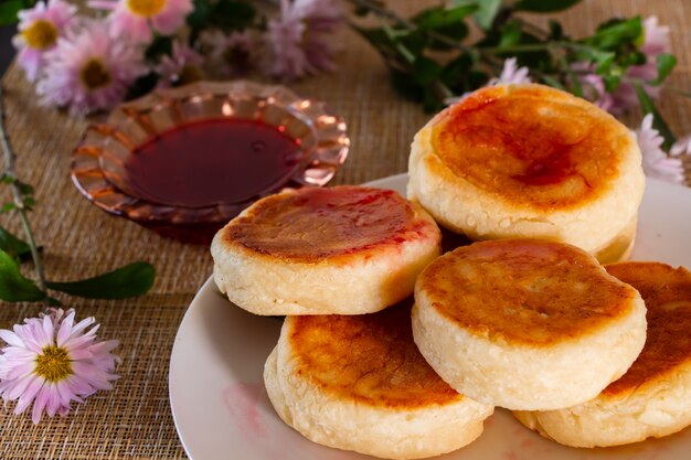 집에서 만든 아침 식사-잼과 사워 크림과 함께 접시에 맛있는 코티지 치즈 팬케이크.