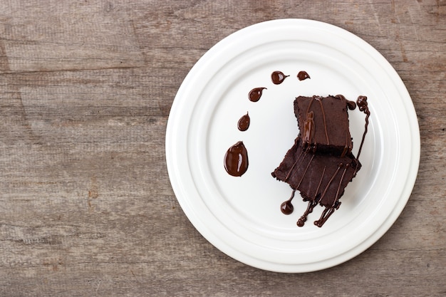 Фото Домашнее пирожное с шоколадной помадкой. сладкий десерт на деревянных фоне.