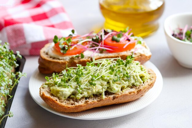 Homemade bruschetta with avocado tomatoes and microgreens Healthy food Tasty breakfast or snack