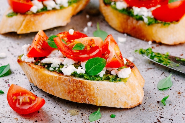 Bruschette fatte in casa al pesto di feta, pomodorini e basilico