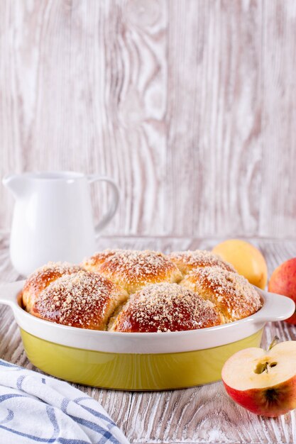 Homemade bun with crumb and jam on a white wooden background. Bun with crumb. Bun sprinkled with crumbs.