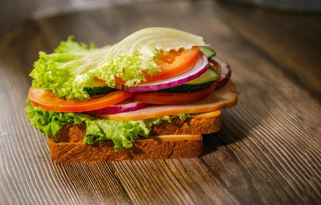 Homemade burger with cutlet onion tomato and salad on rustic wooden background