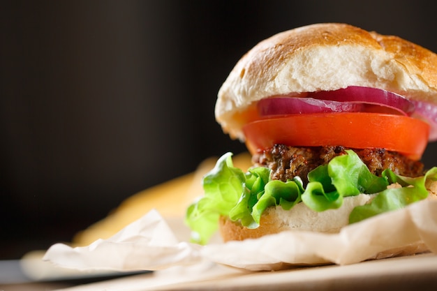 Hamburger fatto in casa con patatine fritte sul tavolo di legno