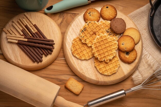 Homemade butter cookies and chocolate chip cookies and stick biscuits on wooden background