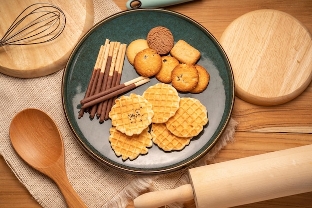 Homemade butter cookies and chocolate chip cookies and stick\
biscuits on wooden background