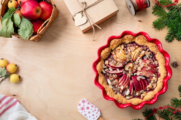 Torta fatta in casa con marmellata di mirtilli rossi e mele rosse fresche su uno sfondo di legno torta di mele per capodanno e natale