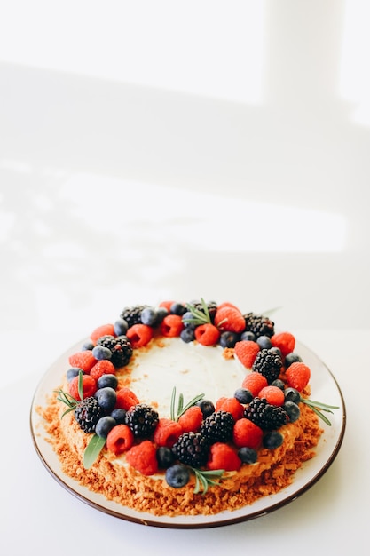 사진 흰 벽 배경 위에 신선한 딸기를 얹은 홈메이드 케이크